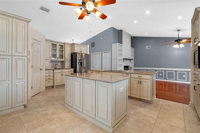 kitchen with a kitchen island, stainless steel appliances, and cream cabinets