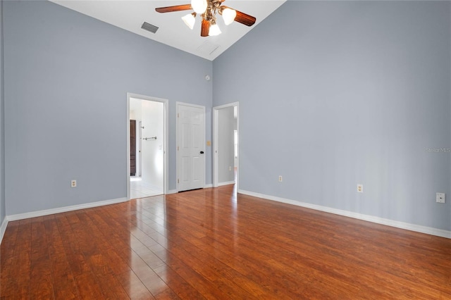 empty room with hardwood / wood-style floors, high vaulted ceiling, and ceiling fan