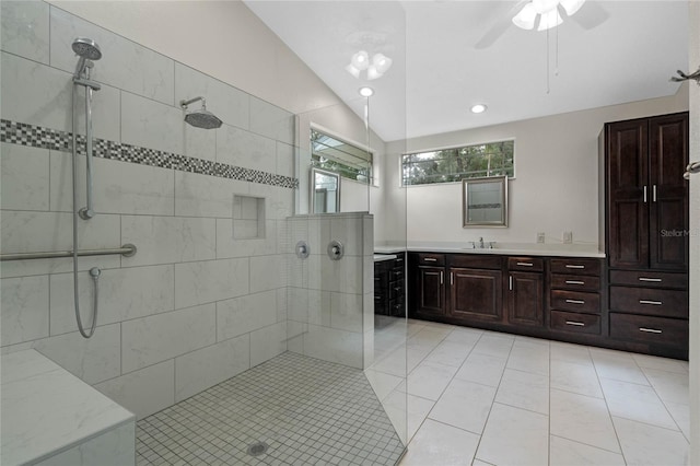 bathroom featuring tiled shower, vanity, vaulted ceiling, and ceiling fan