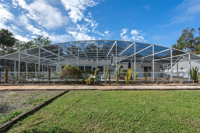 back of property with a lawn and a lanai