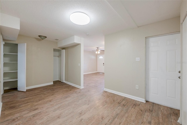 spare room featuring a textured ceiling, ceiling fan, and light hardwood / wood-style flooring