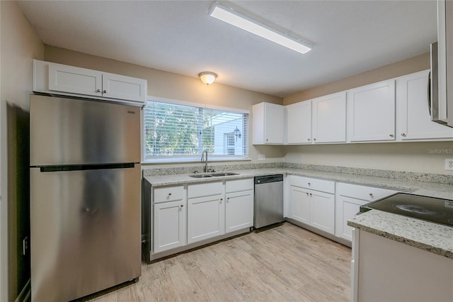 kitchen featuring sink, light stone countertops, appliances with stainless steel finishes, and white cabinetry