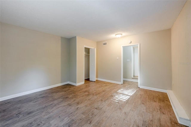 unfurnished bedroom with a closet and light hardwood / wood-style flooring