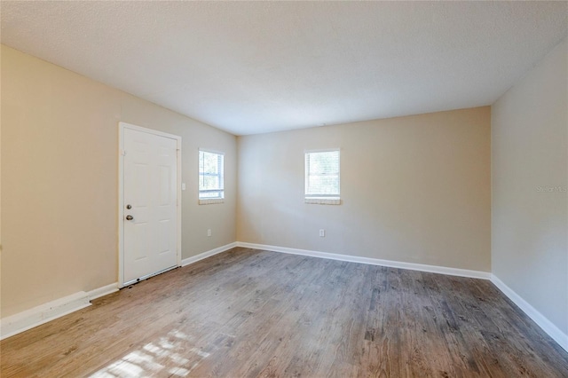 unfurnished room featuring a textured ceiling and hardwood / wood-style floors