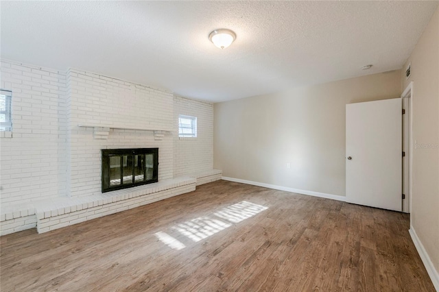 unfurnished living room with a textured ceiling, hardwood / wood-style floors, and a fireplace