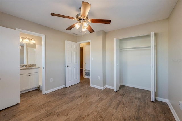 unfurnished bedroom with connected bathroom, a closet, ceiling fan, and light hardwood / wood-style floors