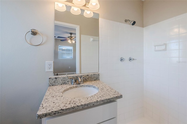 bathroom featuring ceiling fan, tiled shower, and vanity