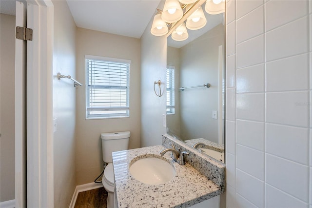 bathroom with toilet, vanity, and hardwood / wood-style flooring