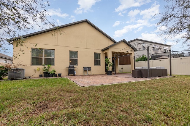 rear view of property featuring a patio area, a yard, and central AC