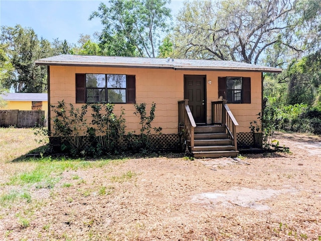 bungalow-style home with fence