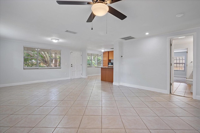 unfurnished living room featuring ceiling fan, light tile patterned floors, and crown molding