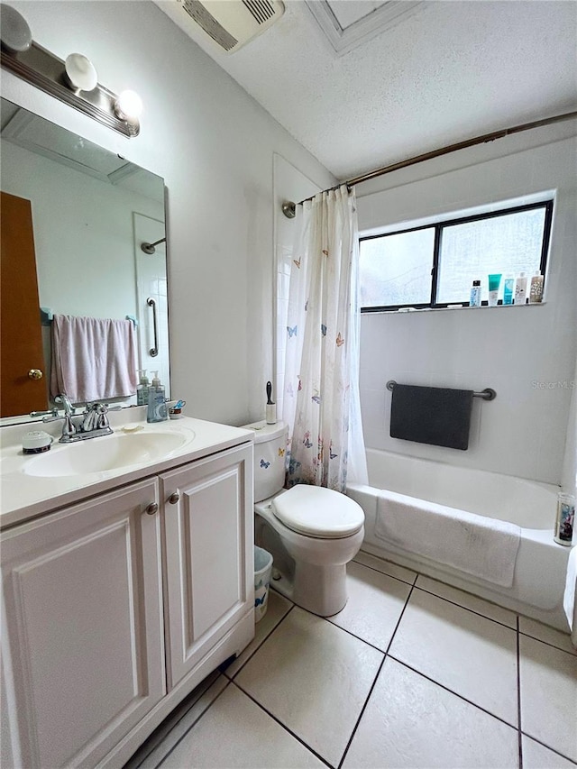 full bathroom featuring shower / tub combo with curtain, tile patterned flooring, vanity, toilet, and a textured ceiling