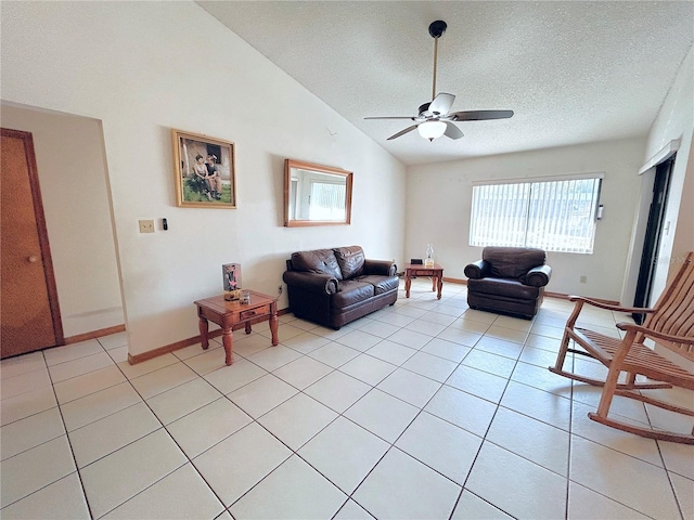 living room with ceiling fan, vaulted ceiling, a textured ceiling, and light tile patterned floors