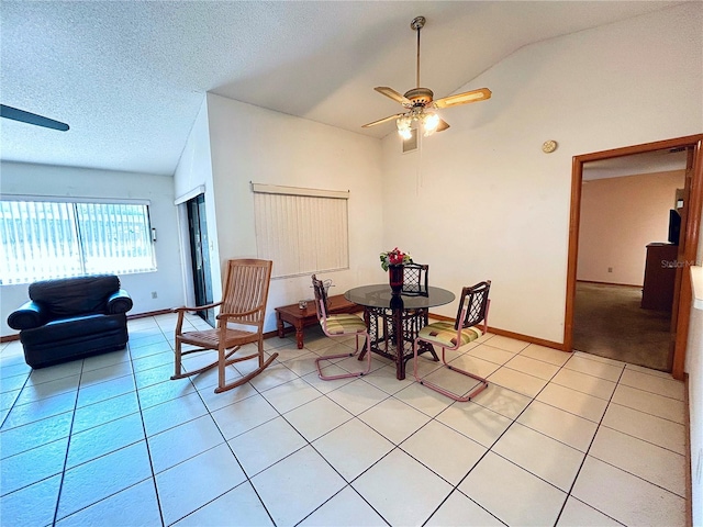 dining space featuring lofted ceiling, light tile patterned floors, a textured ceiling, and ceiling fan