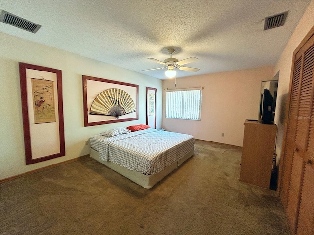 carpeted bedroom with ceiling fan and a textured ceiling