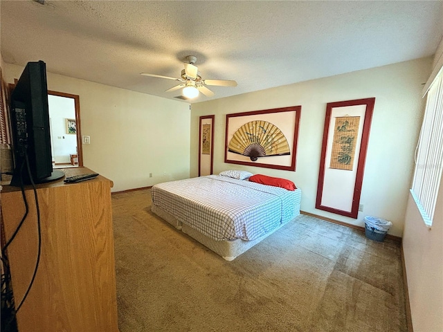 carpeted bedroom with ceiling fan and a textured ceiling