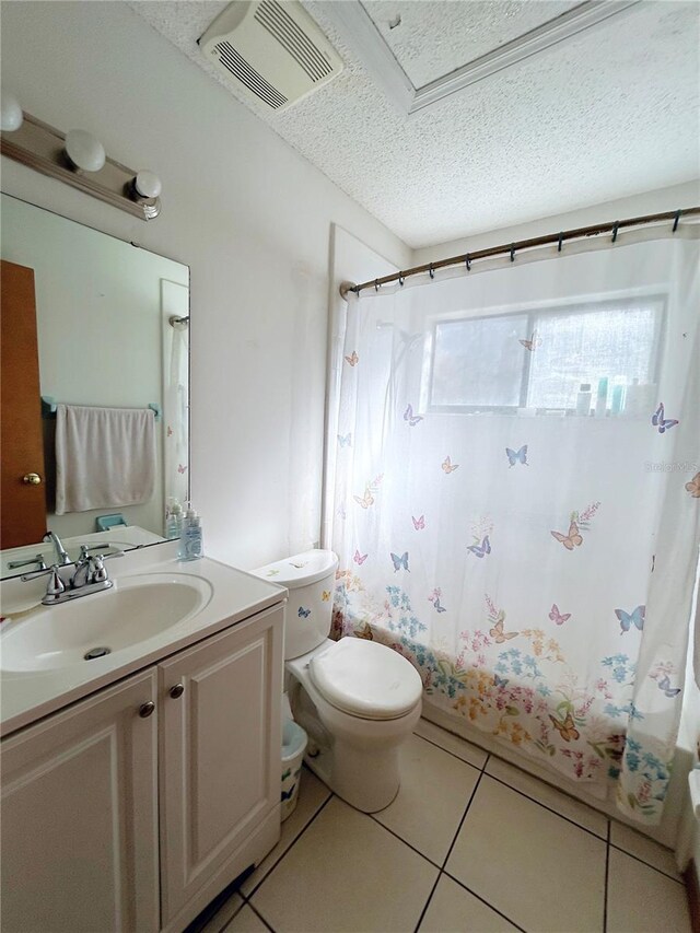 full bathroom featuring tile patterned flooring, vanity, shower / tub combo, toilet, and a textured ceiling