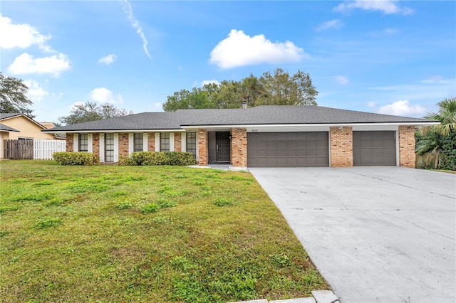 single story home featuring a front lawn and a garage