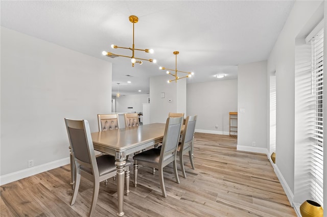 dining room featuring light hardwood / wood-style flooring and an inviting chandelier