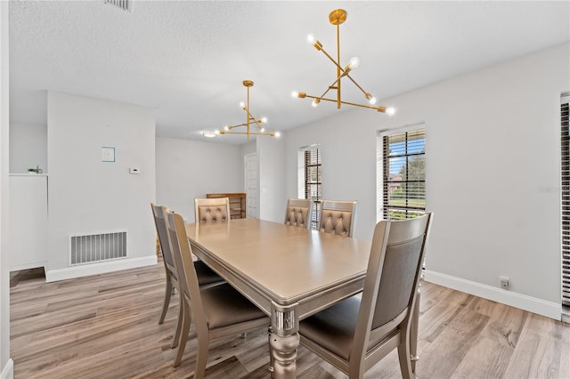 dining room featuring a notable chandelier and light hardwood / wood-style floors