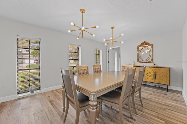 dining area featuring a notable chandelier and light hardwood / wood-style flooring