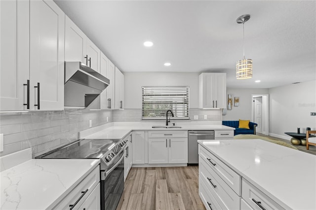 kitchen with sink, hanging light fixtures, light wood-type flooring, white cabinetry, and stainless steel appliances