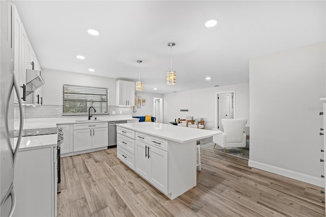 kitchen with hanging light fixtures, a kitchen island, light hardwood / wood-style floors, white cabinetry, and stainless steel appliances