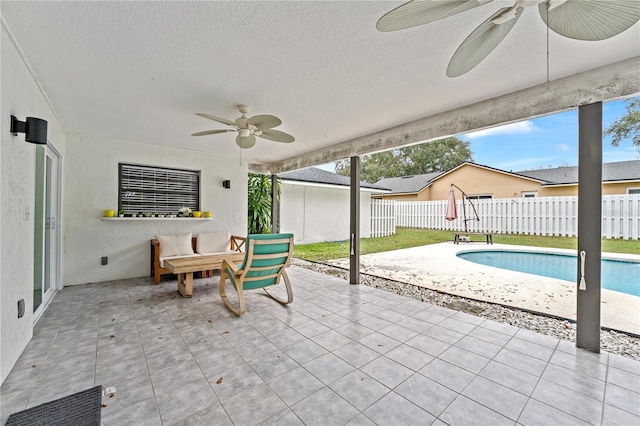 view of patio with a fenced in pool and ceiling fan