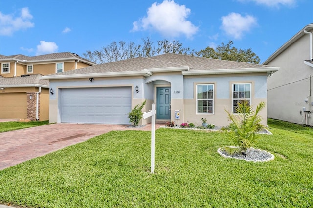 view of front of property with decorative driveway, an attached garage, a front lawn, and stucco siding