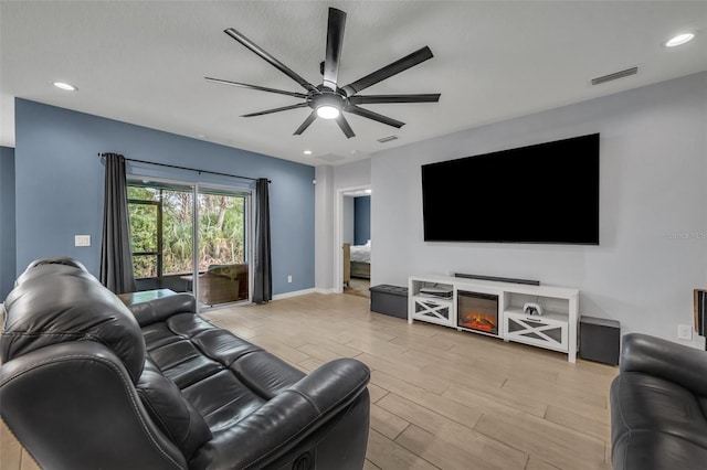 living area featuring visible vents, baseboards, a ceiling fan, light wood-style floors, and recessed lighting