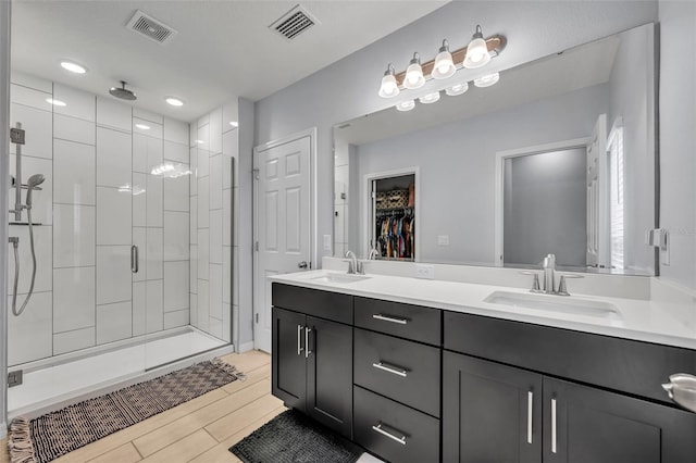 bathroom with visible vents, a sink, and a shower stall