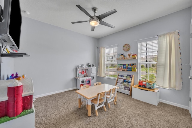 recreation room with ceiling fan, carpet floors, and baseboards