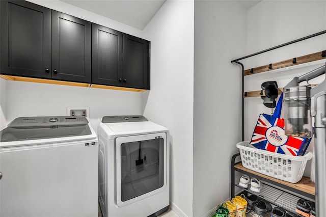 clothes washing area with baseboards, cabinet space, and washer and dryer