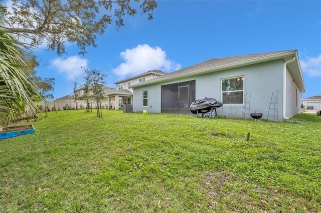 rear view of house featuring cooling unit, a lawn, fence, and stucco siding