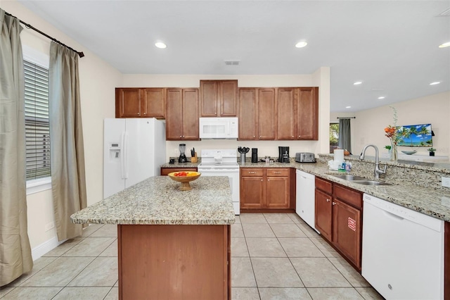 kitchen with kitchen peninsula, light tile patterned flooring, white appliances, and sink