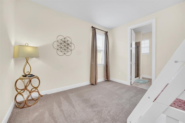 unfurnished bedroom featuring light colored carpet and ensuite bath