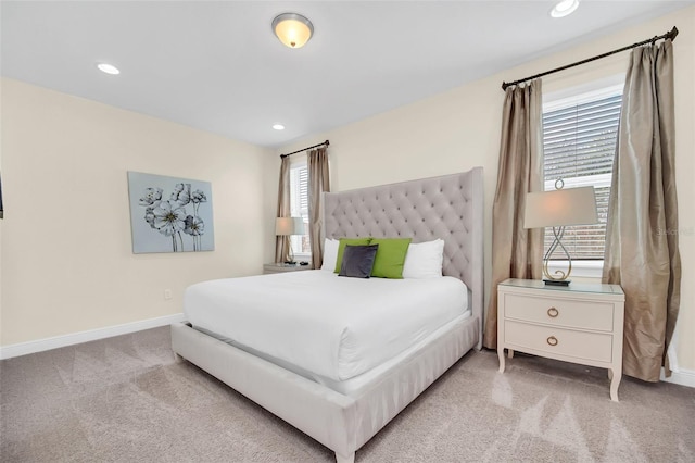 bedroom featuring light colored carpet and multiple windows