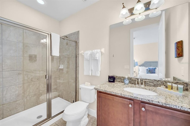 bathroom featuring tile patterned flooring, vanity, a shower with shower door, and toilet