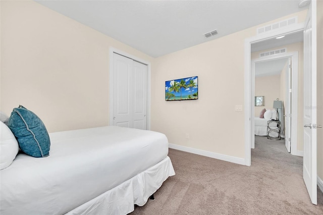 bedroom featuring light carpet and a closet