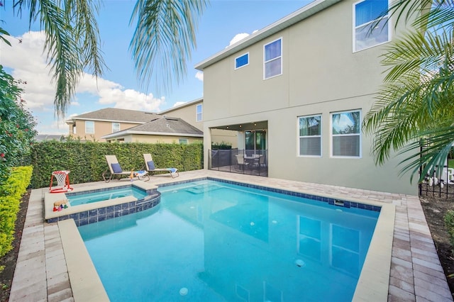 view of swimming pool featuring a patio area and an in ground hot tub