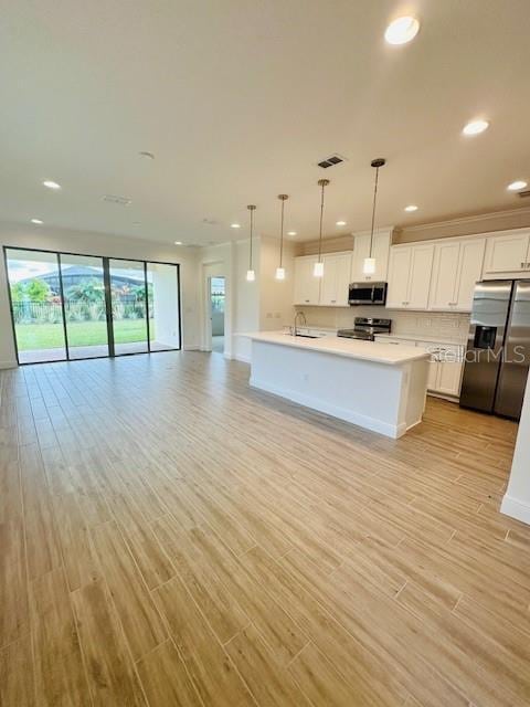 kitchen featuring decorative light fixtures, light wood-type flooring, white cabinetry, and stainless steel appliances