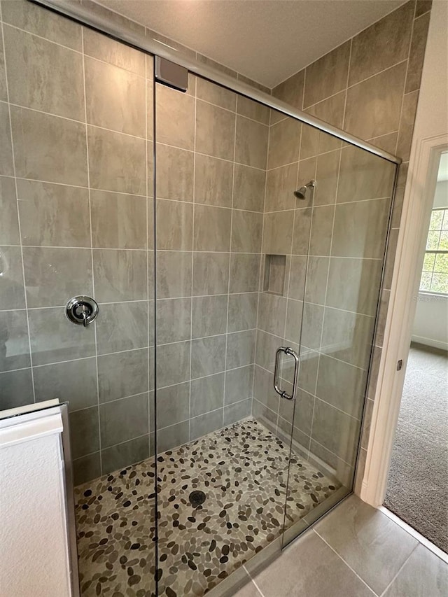 bathroom featuring an enclosed shower and tile patterned flooring