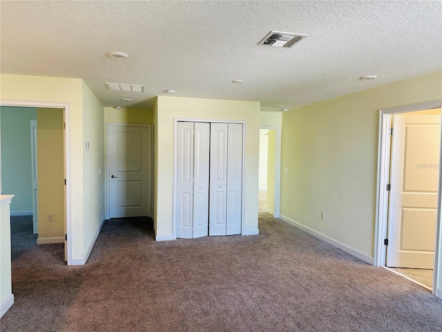 unfurnished bedroom featuring carpet flooring, a closet, and a textured ceiling