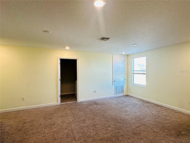 carpeted spare room featuring a textured ceiling