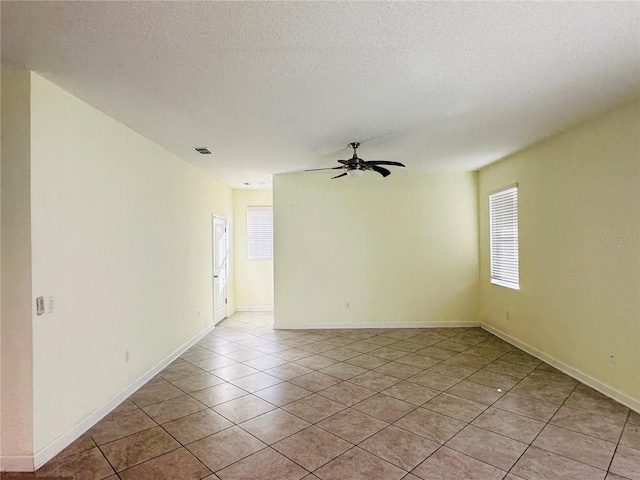 tiled spare room featuring ceiling fan and a textured ceiling