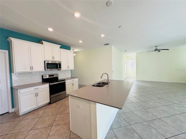 kitchen featuring white cabinetry, sink, appliances with stainless steel finishes, and an island with sink