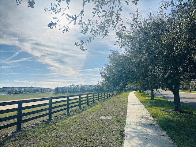 view of community with a rural view and a yard