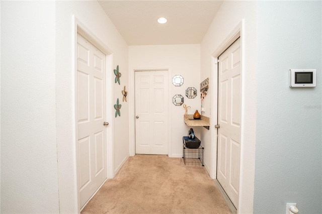 corridor featuring light colored carpet