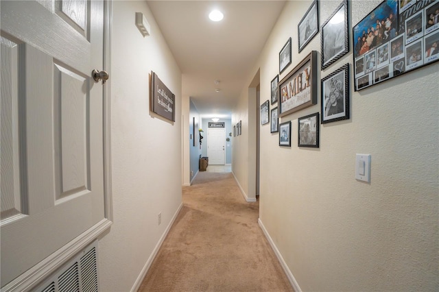 hallway featuring light colored carpet