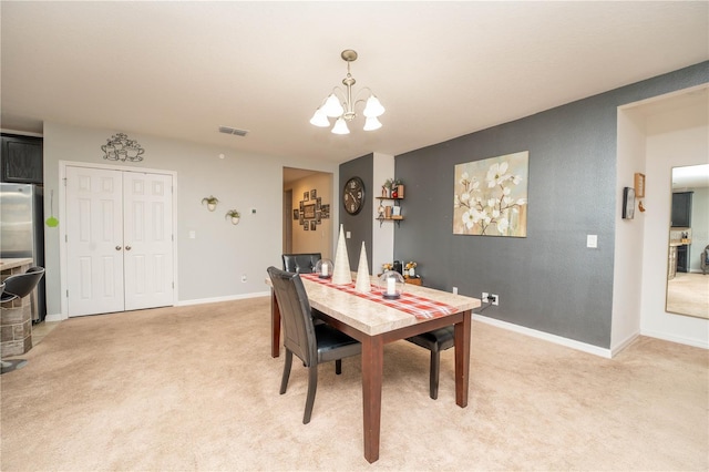 dining room featuring light colored carpet and an inviting chandelier